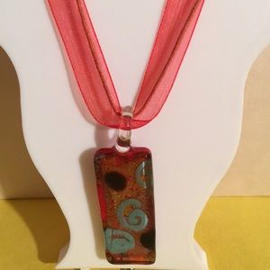 Red ribbon/string necklace with glass pendant.